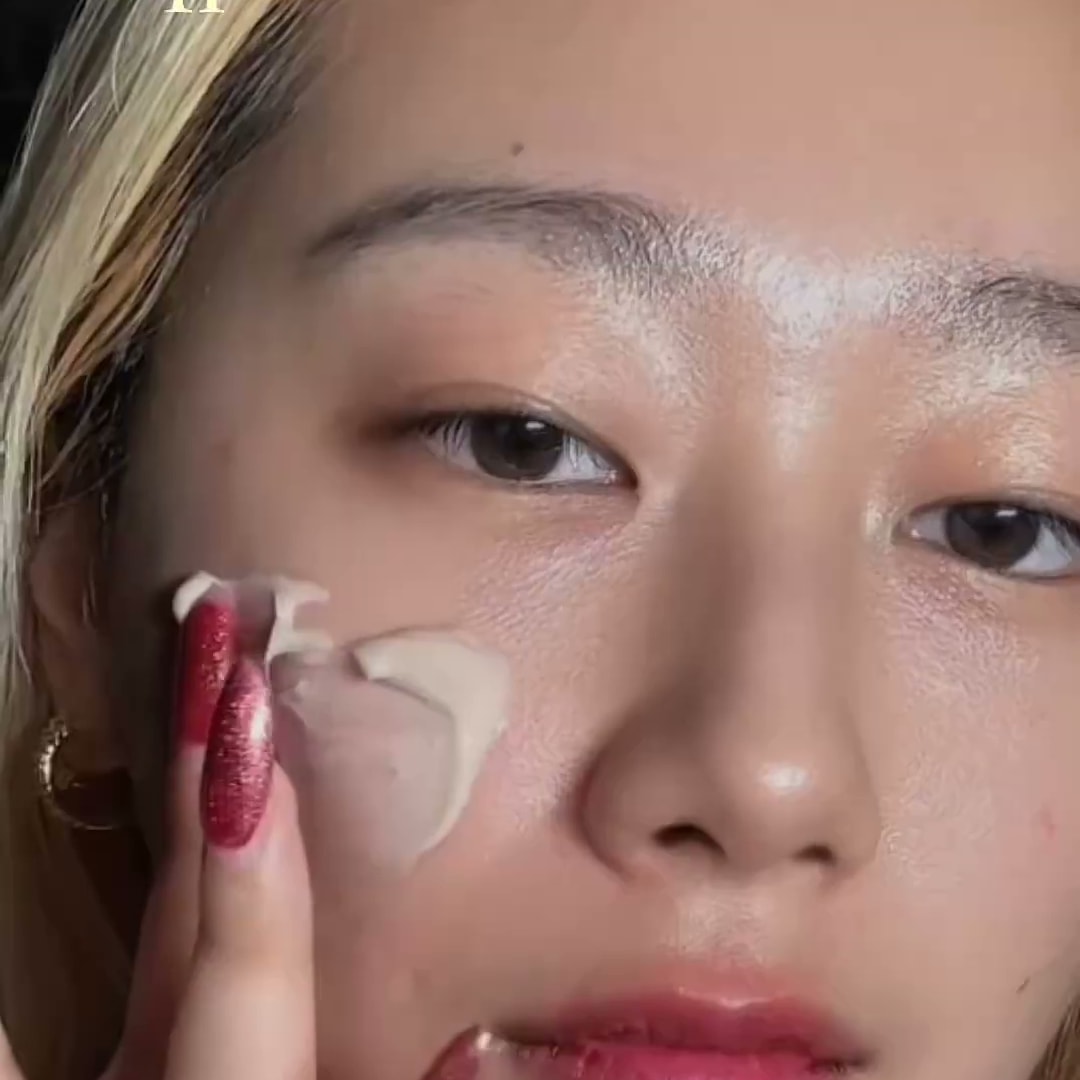 크리에이터가 손끝으로 볼에 크림 제형을 펴 바르는 얼굴 클로즈업 장면