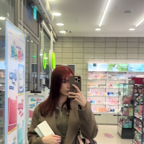 국내 매장 진열대 앞에서 제품을 고르며 촬영하는 러시아어권 크리에이터의 세로형 숏폼 컷