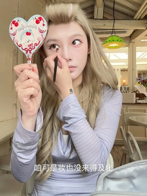 카페에서 화장을 고치는 장면을 중국어 자막과 함께 세로 화면으로 담은 콘텐츠