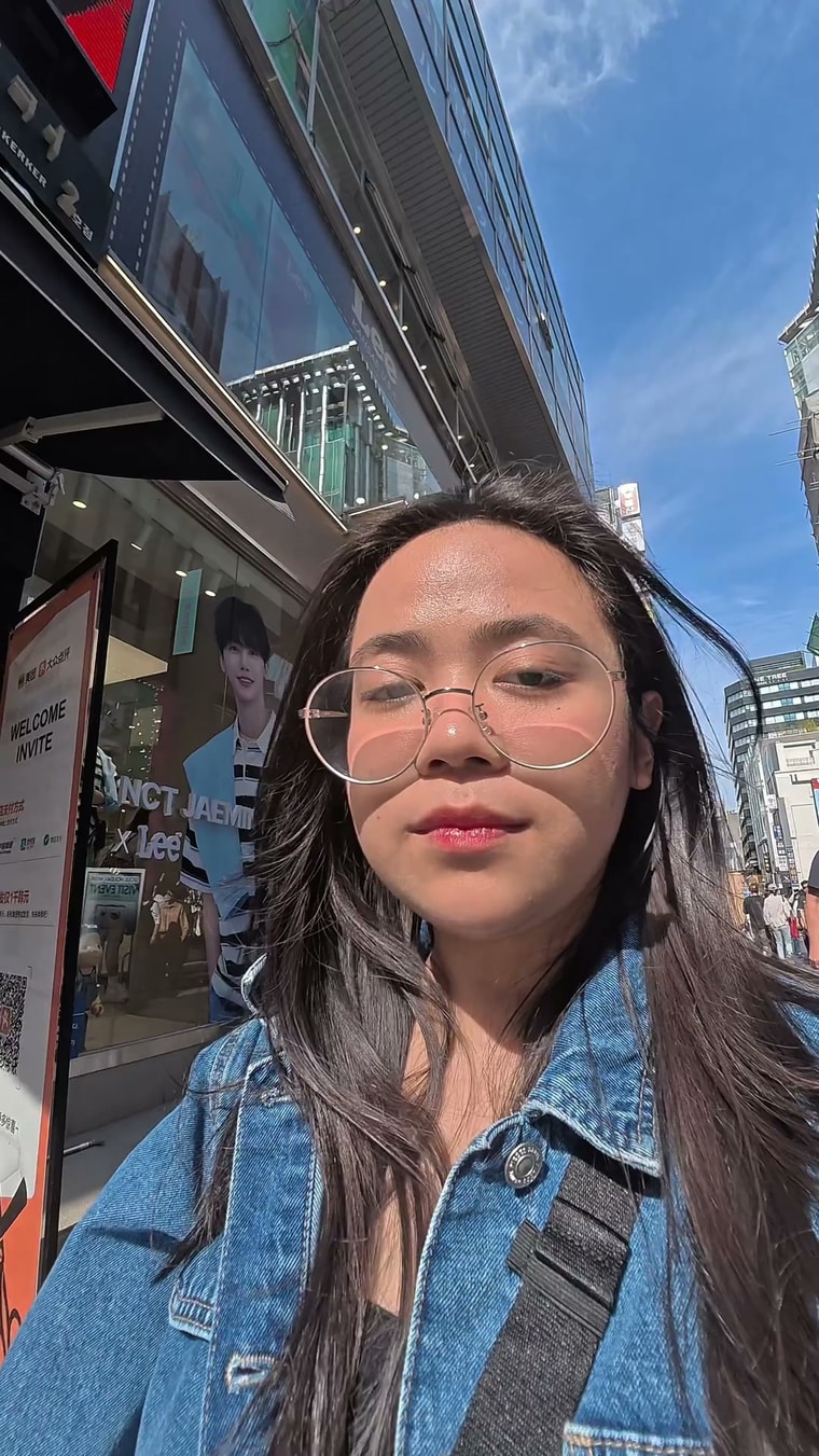 서울 도심 거리에서 하늘을 배경으로 셀프 촬영하며 걷는 크리에이터의 세로형 콘텐츠 컷