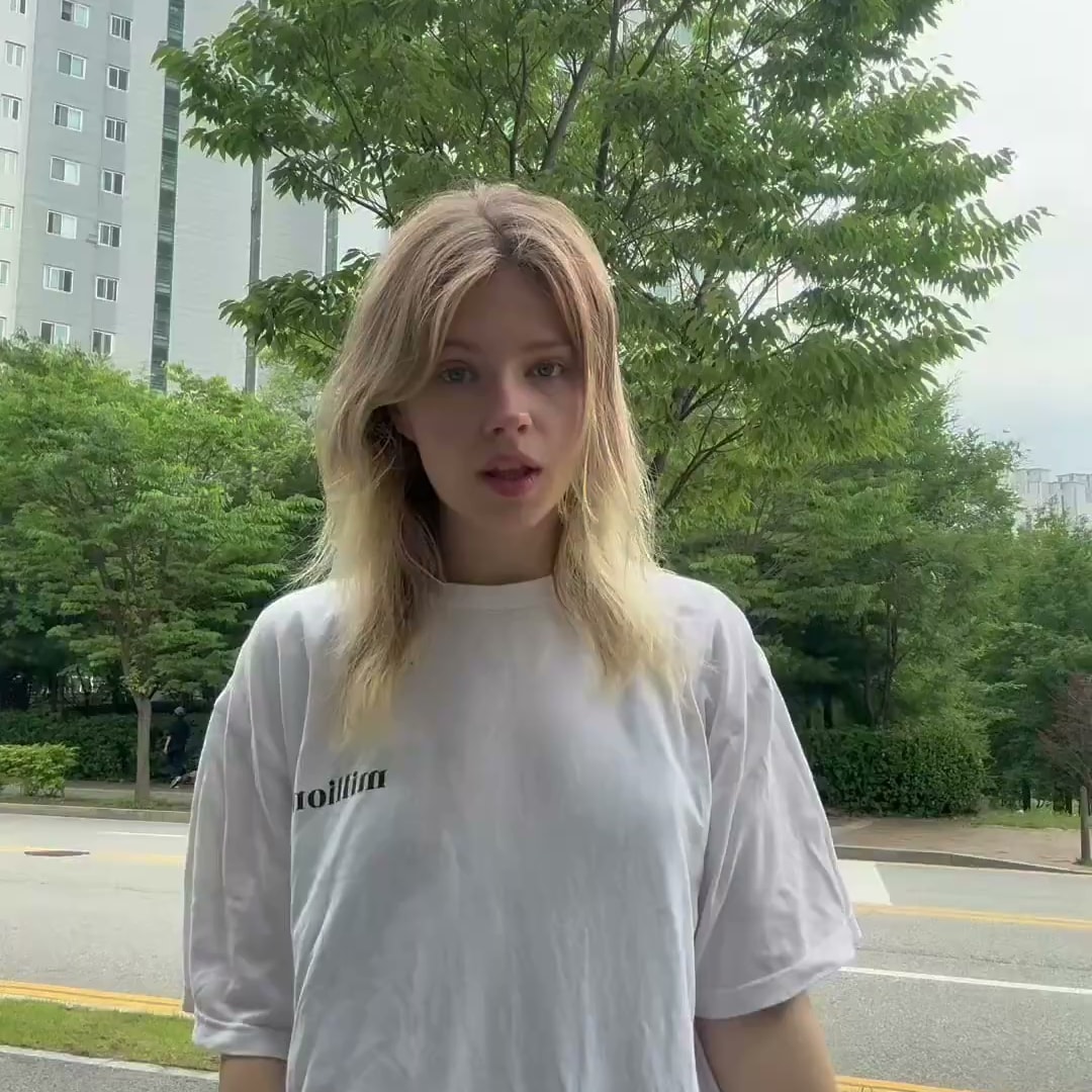 아파트 단지 앞 거리에서 이야기를 시작하는 영어권 크리에이터의 콘텐츠 장면