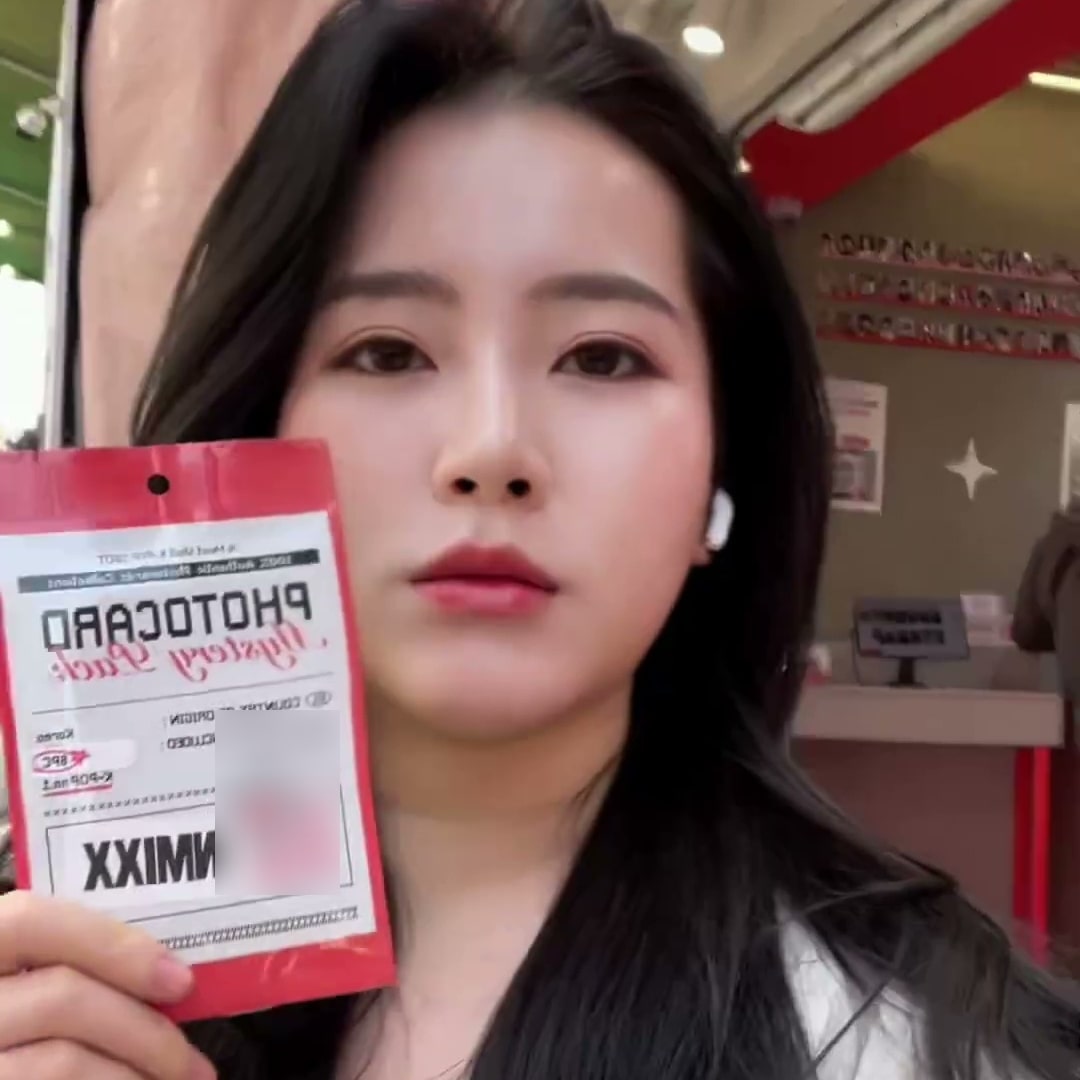 구매한 포토카드 팩을 카메라 앞에 들어 보이는 아시아권 크리에이터