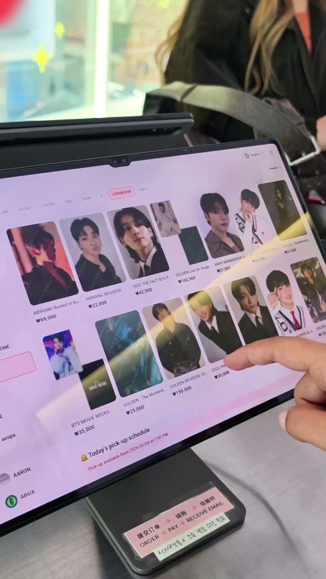 크리에이터가 매장 키오스크 화면을 손가락으로 짚으며 상품 목록과 주문 단계를 설명하는 세로형 콘텐츠 장면