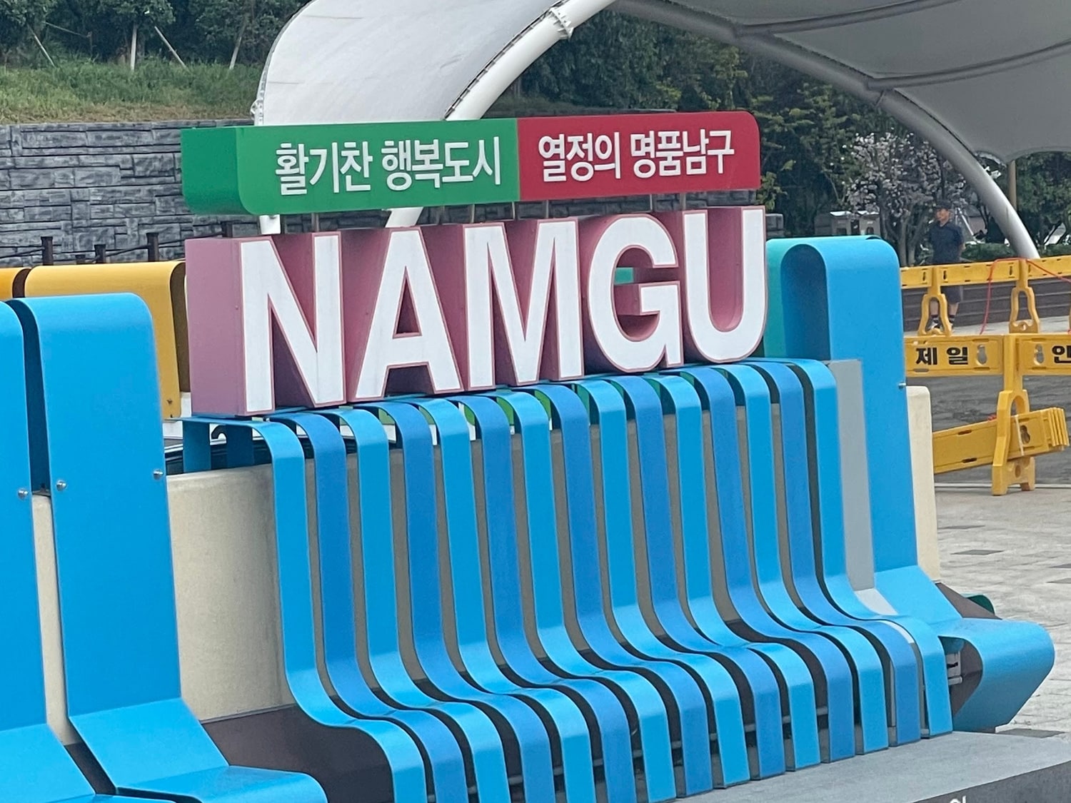 대구 남구의 야외 공원에 설치된 NAMGU 조형물과 활기찬 행복도시 열정의 명품남구 문구가 적힌 표지판