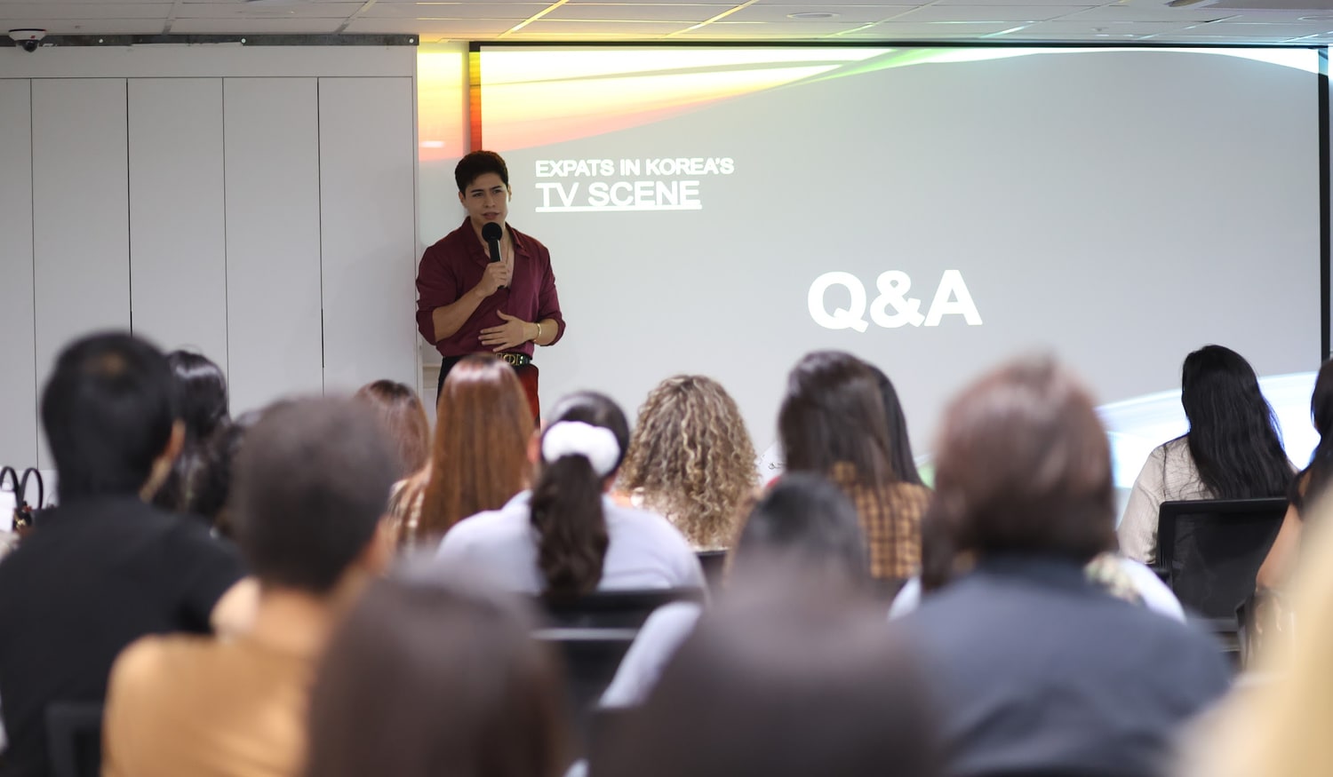 Soo House 세션 현장. 앞에 선 진행자가 마이크를 들고 있고 뒤 화면에 Q&A 슬라이드가 떠 있으며, 참가자들이 뒷모습으로 앉아 있다.